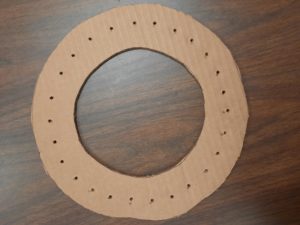 example of 10 inch cardboard circle with 26 holes punched in it.