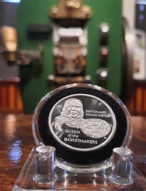 Datsolalee Commemorative Medallion is displayed in front of historic Coin Press No. 1.